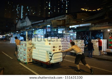 HONG KONG, AUGUST 14:  workers move the boxes in Yau Ma Tei Wholesale Fruit Market at night on 14 august 2013. it take 80% fruit wholesale in hong kong and one of main asia fruit wholesale market