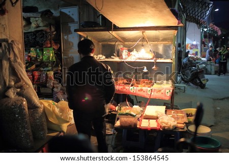 PUNING, CHINA - MARCH 17: the unidentified man sells homemade meat in food store with no hygiene in Guangdong on March 17 2013.food safety become the main issue in modern china