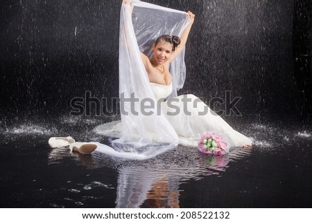girl in white dress lays in water studio