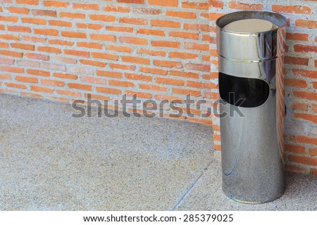 Garbage bin of steel stainless wall brick background.