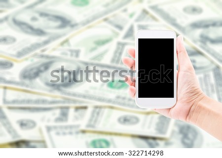 Mobile Phone making money for concept on Dollar blur background.