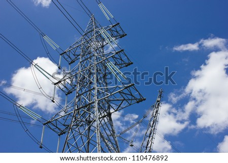 long lines of power-line towers stretching across a blue Sky