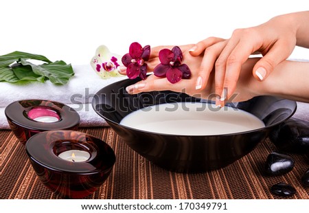 Woman\'s hands with orchids and bowl of milk