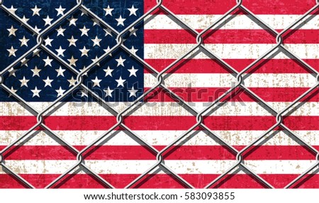 USA Flag behind steel wire fence.