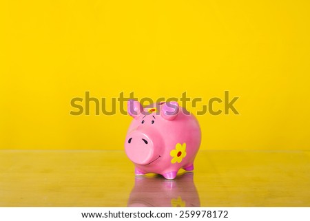 Piggy coin bank on yellow background . Cute white ceramic piggy coin bank. Money savings.Financial security,Personal funds.Spring.
