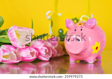 Piggy coin bank on yellow background with flowers. Cute white ceramic piggy coin bank. Money savings.Financial security,Personal funds.Spring.