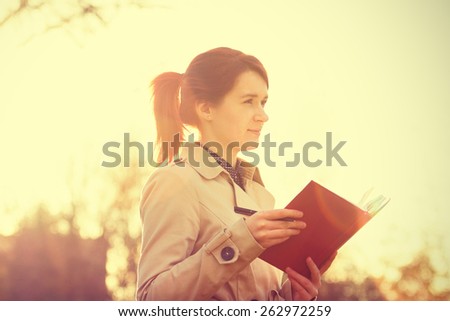 Young businesswoman with a thoughtfully emotion,student professional outdoors holding a red journal.Businesswoman,Life style.