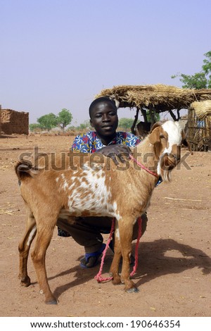 KOKEMNOURE, BURKINA FASO - FEBRUARY 23: A young farmer from the village of Kokemnoure is proud to be photographed with his goat, February 23, 2007.