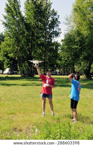 CARDET, FRANCE - MAY 25: Two adults in the countryside having fun with a drone equipped with a mini camera, may 25, 2015.