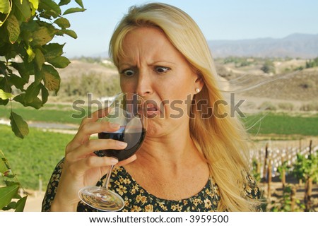 Beautiful woman at a country winery wearing her sun dress on a summer day. Apparently the wine is not so good there.