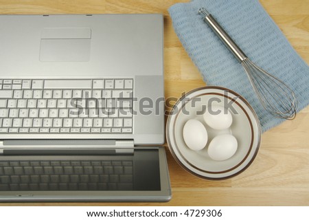 Laptop, eggs and mixer - online research for cooking and recipe information.