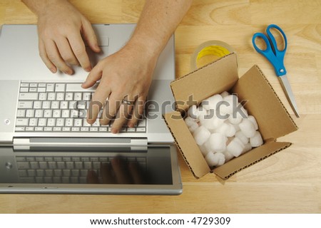 Businessman Works on Laptop with Packaging materials at his side.