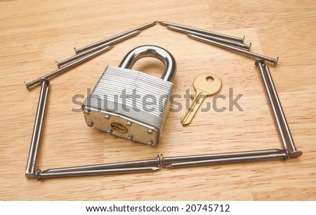 House of Nails with Lock and Key on a Wood Background.