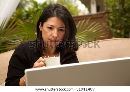 Hispanic Woman with Coffee and Laptop On Her Patio.