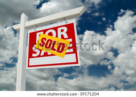 Sold For Sale Real Estate Sign on Cloudy Sky.