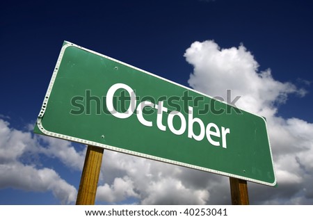 October Green Road Sign with dramatic blue sky and clouds - Months of the Year Series.