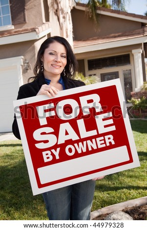 Happy Attractive Hispanic Woman Holding For Sale By Owner Real Estate Sign In Front of House.