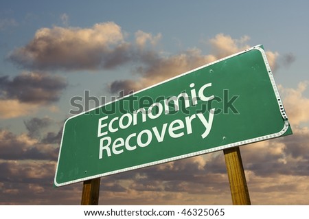 Economic Recovery Green Road Sign with dramatic clouds and sky.