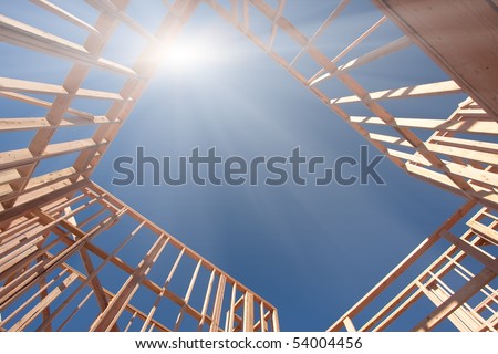 New Construction Framing Abstract with Sunburst Over Clear Blue Sky.