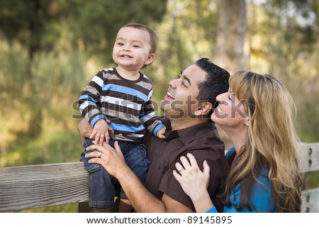 Happy Mixed Race Ethnic Family Having Fun Playing In The Park.