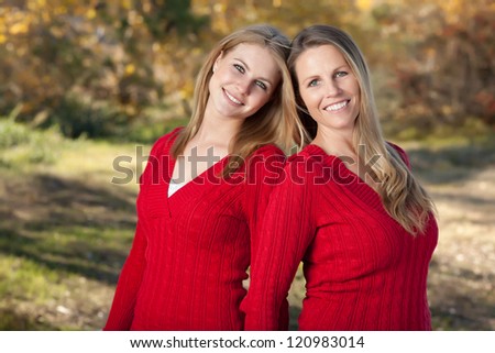 Pretty Mother and Daughter Portrait in the Park on a Fall Day.