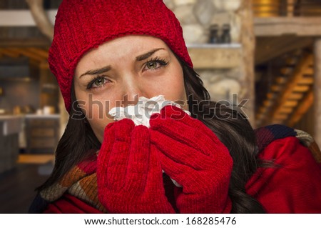 Miserable Sick Woman Inside Log Cabin Blowing Her Sore Nose With Tissue.