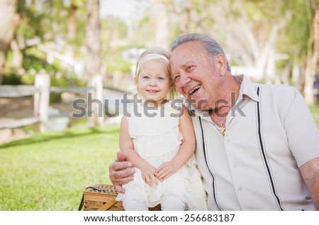 Loving Grandfather and Granddaughter Hugging Outside At The Park.