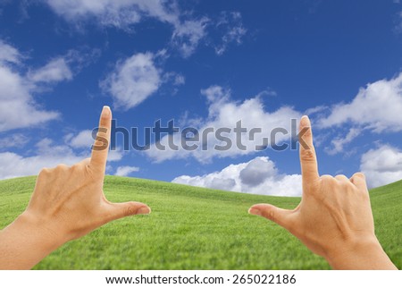 Female Hands Framing Beautiful Deep Blue Sky Above Lush Green Grass Field.