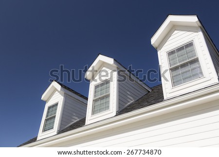Roof of House and Windows Against Beautiful Deep Blue Sky.