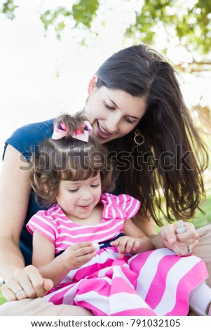 Mixed Race Young Mother And Cute Baby Girl Applying Fingernail