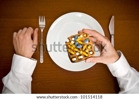 Poisons for eating. Human hand hold waffle with pills from top view.