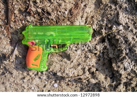 toy gun laying on the sandy beach
