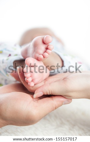 baby foot into parents hands. Family concept