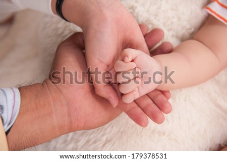Closeup of baby hand into mother and father hands. Family concept