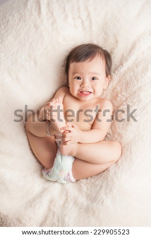 Beautiful expressive adorable happy cute laughing smiling asian baby infant face showing tongue, isolated.