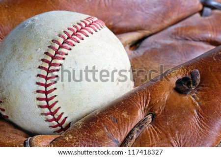 Closeup of old and weathered baseball leather glove and ball
