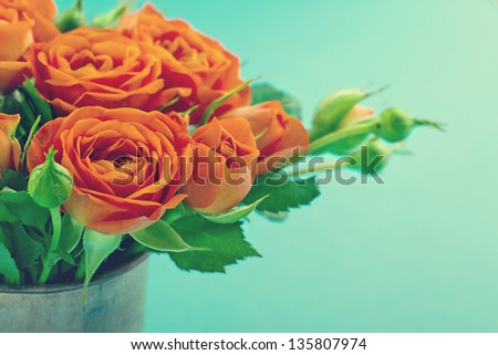 Bouquet of orange roses in a vase on vintage shabby chic background