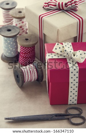 Christmas present wrapping background, wooden vintage ribbons spools and gift boxes and wrapping paper rolls