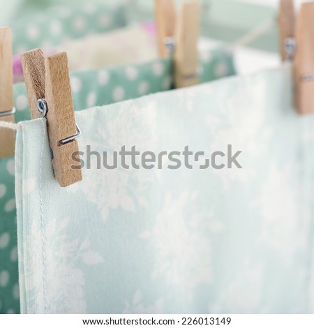 Closeup of pastel color laundry drying on vintage wooden drying rack with copy space