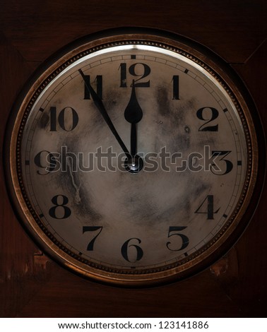 Old clock showing five minutes to midnight