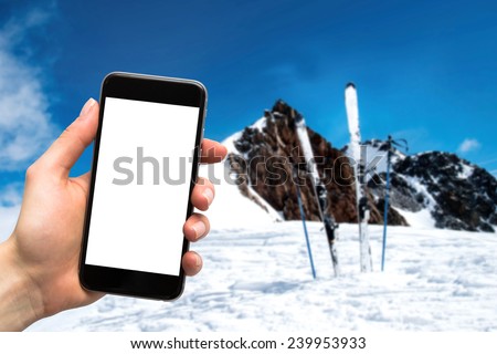 phone in the hands of women and skis in the background