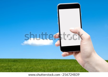 Phone in the hand with a blank screen and a sky background with a meadow