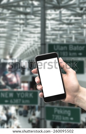 Phone in the hands of the woman at the airport. Blurred background.