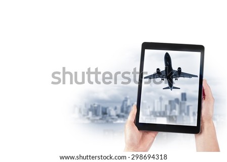 tablet in the hands and the plane over the city