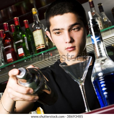 Barman with shaker making cocktail. Focus on face.