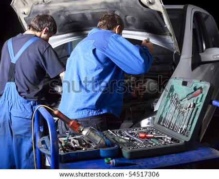 auto mechanics repairing a car engine. Different working tools on foreground
