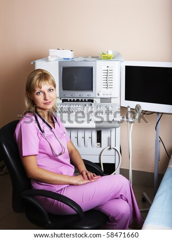 Portrait of female doctor near ultrasound equipment at modern clinic.