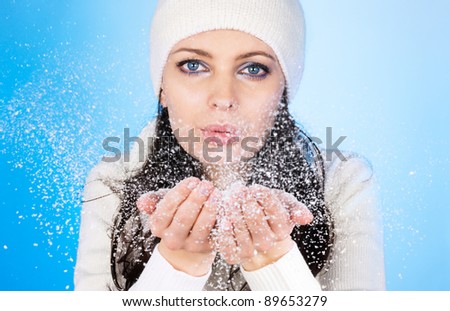 Winter girl and snow flakes. Focus on eyes.