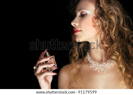 Beautiful woman applying perfume on her neck. Space for text.