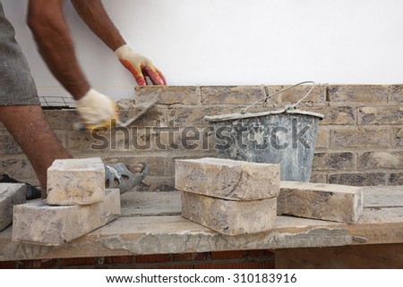 Construction. Bricklayer worker building walls. Space for text.